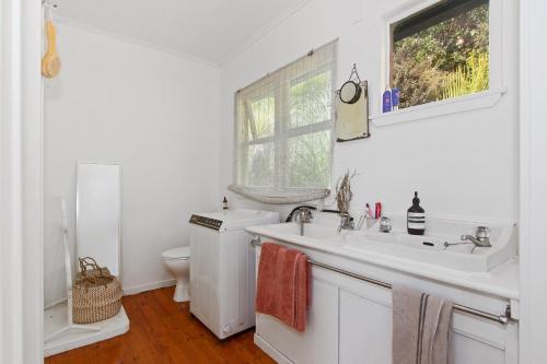 旺阿雷Kereru Cottage - Matapouri Holiday Home的白色的浴室设有水槽和卫生间。