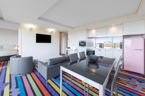 悉尼Adge Hotel and Residence - Adge Queen - Australia的客厅配有桌子和沙发