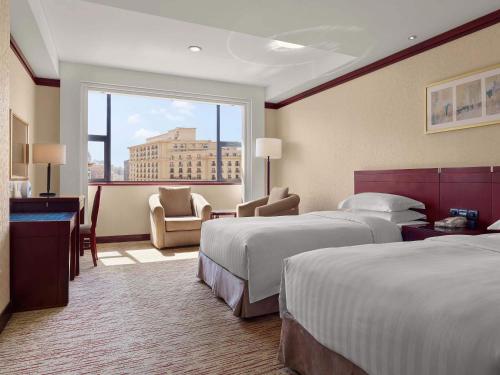 北京北京保利大厦的酒店客房设有两张床和大窗户。