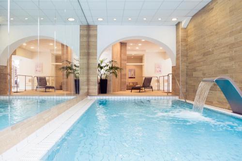 布里德莱班Grand Hôtel des Thermes Brides-les-Bains的一座带水滑梯的酒店游泳池