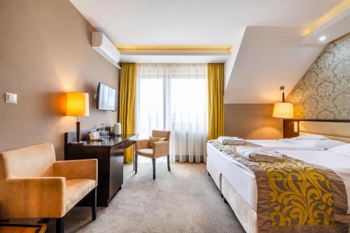 比亚沃维耶扎彼奥维斯基酒店/会议及康体中心/Spa的配有一张床和一张书桌的酒店客房