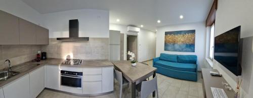 巴多利诺Cabà Holiday Bardolino Gritti的厨房以及带蓝色沙发的客厅。