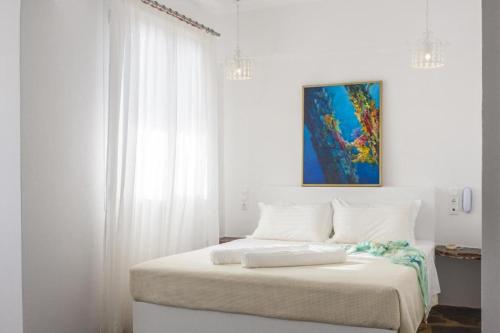 萨摩斯天蝎座公寓酒店及套房的白色卧室配有白色窗帘的床