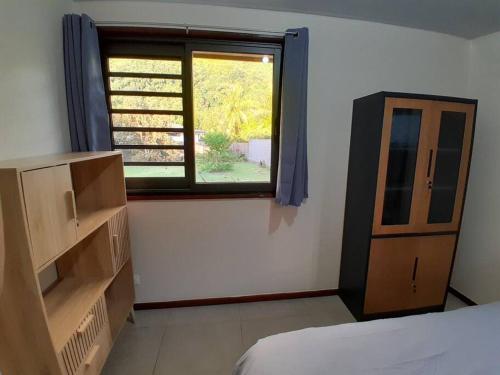 PaeaPaea Lodge的一间卧室设有窗户、一张床和一个梳妆台