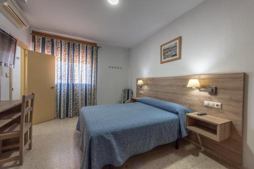 赫雷斯-德拉弗龙特拉圣安德烈斯酒店的一间卧室配有蓝色的床和木制床头板