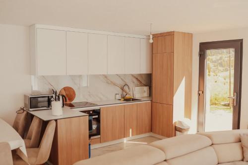佩奇Bujtina e Gjyshes的一间厨房,内设白色橱柜和沙发