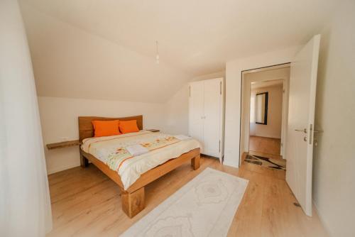 佩奇Bujtina e Gjyshes的一间卧室配有一张带橙色枕头的床