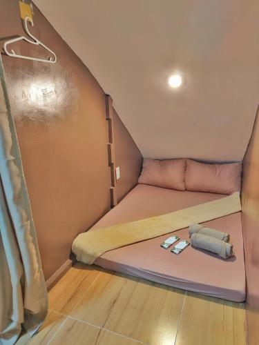 PusokCozy Cabin Hostel In Mactan Near Airport的一个小房子里的一张小床,配有两个枕头