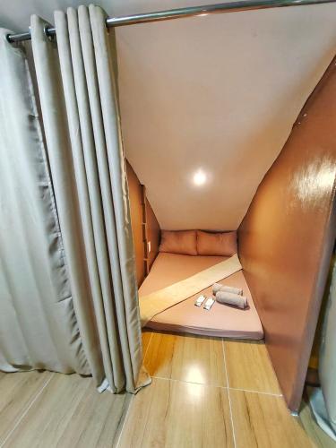 PusokAashvi cozy cabin hostel close to mactan cebu airport的一个小房间里一张小床,有窗帘