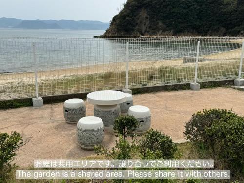 直岛町Vacation House YOKOMBO的享有海滩景致的野餐区