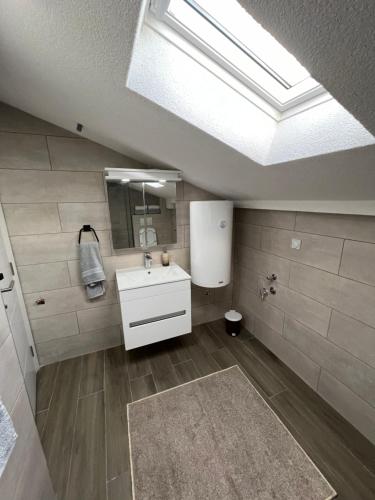 尼什LiboroApartments的浴室配有白色水槽和天窗。