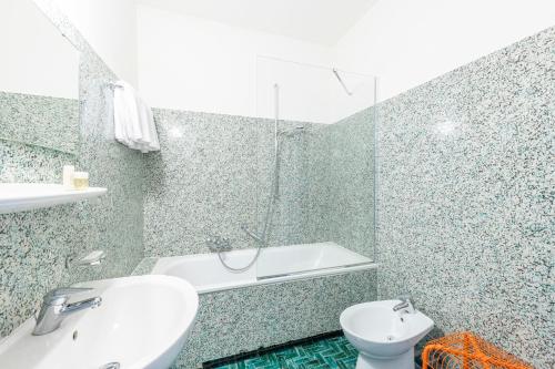 卢加诺艾特兰蒂科酒店的带浴缸、盥洗盆和卫生间的浴室