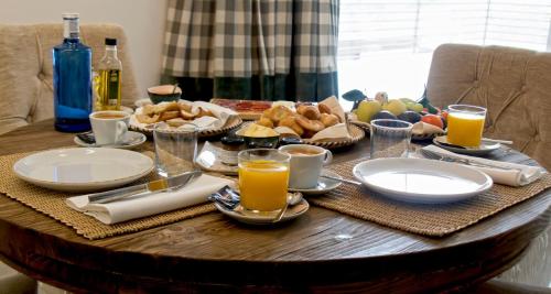 塞夫雷罗斯Hotel TIERRAS DE CEBREROS的一张桌子,上面有早餐食品和橙汁