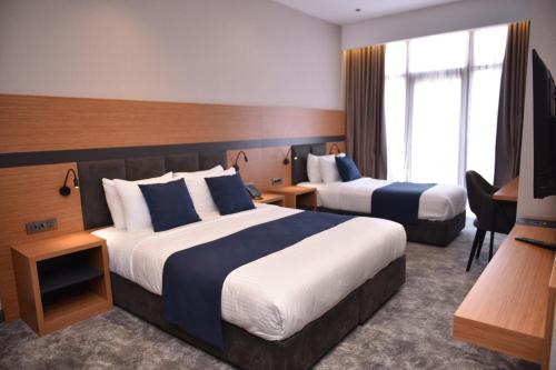 巴统Hotel Monarch的酒店客房设有两张床和电视。