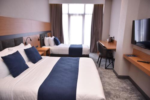 巴统Hotel Monarch的酒店客房设有两张床和一台平面电视。