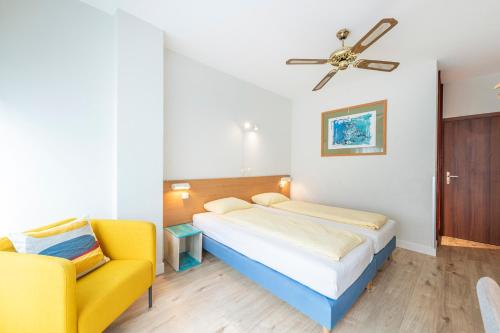 卢加诺艾特兰蒂科酒店的一间卧室配有一张床和一张黄色椅子