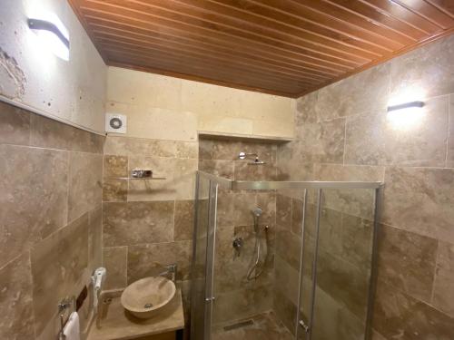 恰乌辛Cappadocia Fairy Tale Suites的带淋浴和盥洗盆的浴室