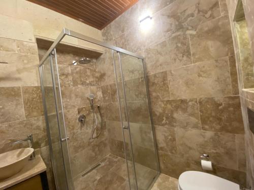 恰乌辛Cappadocia Fairy Tale Suites的带淋浴、卫生间和盥洗盆的浴室