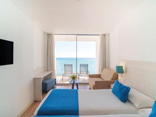 贝纳尔马德纳Hotel Benalmadena Beach的酒店客房设有一张床,享有海景。