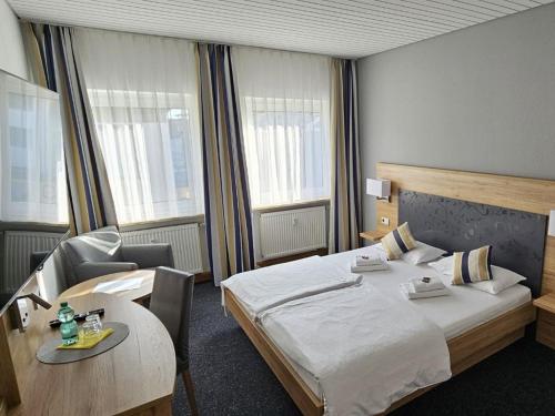 金茨堡Hotel Hirsch Günzburg的酒店客房配有一张床铺和一张桌子。