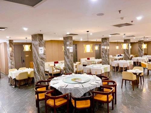 胡志明市Wah Fu Hotel的一间设有白色桌椅的用餐室