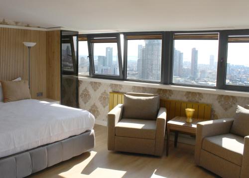 伊斯坦布尔Aram Otel Business & Luxury的一间卧室配有一张床、两把椅子和窗户