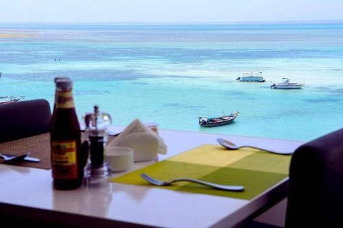 肯杜瓦SunSeaBar Beach Resort的一张桌子和一瓶啤酒,享有海景