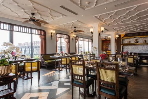 河内河内特兰特酒店的用餐室设有桌椅和窗户。