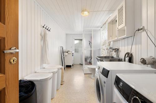 特罗姆瑟Boukersen Heim的白色的浴室设有洗衣机和水槽。