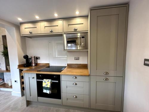 赫尔Deluxe Stays @ Libra Spaces的厨房配有白色橱柜和炉灶烤箱。