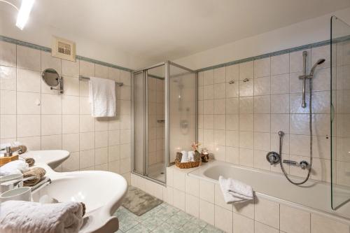 蒂罗尔州圣约翰Hochfeldalm的带浴缸、水槽和淋浴的浴室