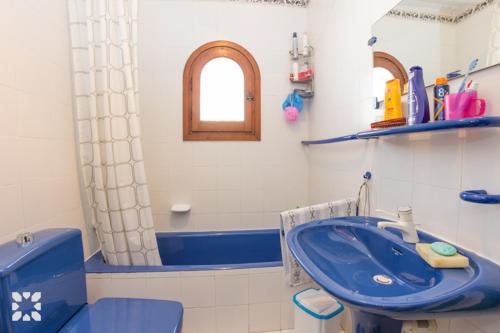 卡尔佩Villa Nani by Abahana Villas的浴室配有蓝色水槽和卫生间。