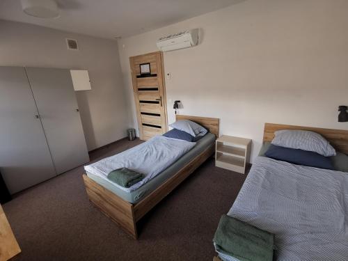 弗罗茨瓦夫Bemma Apart Hostel的一间卧室配有两张单人床和一个衣柜
