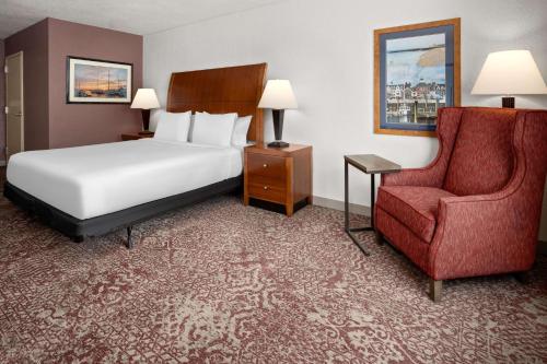米尔福德迈尔福德希尔顿花园旅馆的配有一张床和一把椅子的酒店客房