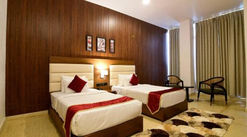 新德里Hotel Airport Sinon by Dream Laxmi New Delhi At IGI Airport的酒店客房配有两张床和一张书桌