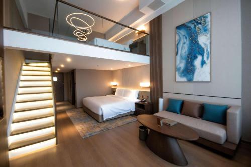 大连大连中天温德姆酒店的酒店客房设有床、沙发和楼梯。