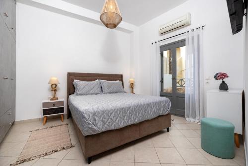 莫诺利索斯加布里埃尔公寓的一间卧室配有一张床和蓝色凳子