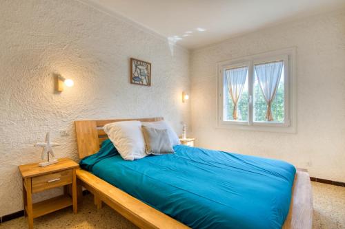 莱斯卡拉Ginajeflo的一间卧室配有一张带蓝色床单的床和一扇窗户。