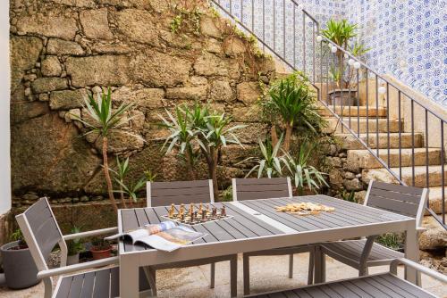 波尔图Porto Lounge Hostel & Guesthouse by Host Wise的一个带石墙的庭院里的桌椅