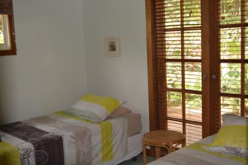 飞鱼湾木槿之家旅馆的一间卧室设有一张床、一个窗口和一张桌子