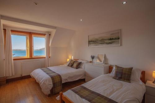 卡斯尔贝Castlebay View的一间卧室设有两张床和窗户。