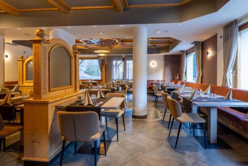 蒂奥内迪特伦托多洛米蒂索恩酒店的餐厅设有桌椅和镜子