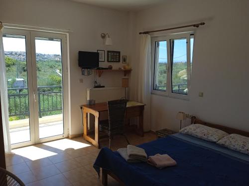干尼亚Manolo s olive farm, apartment with seaview的一间卧室配有一张床、一张书桌和一个窗户。