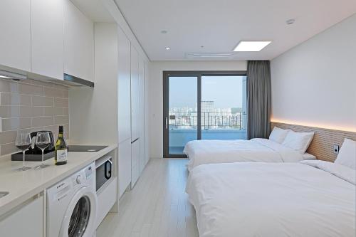 束草市World Sky Residence Hotel的酒店客房设有两张床和洗衣机。