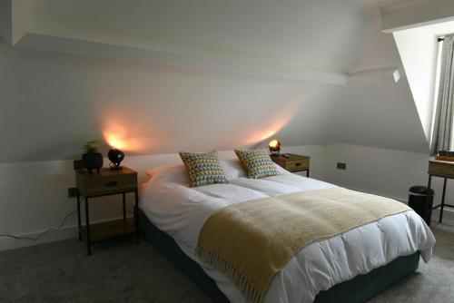 Woburn SandsThe Almshouse Suites的一间卧室配有一张带2个床头柜的大床