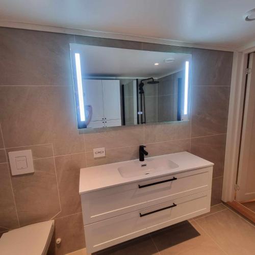 波什格伦Apartment in the city的浴室设有白色水槽和镜子