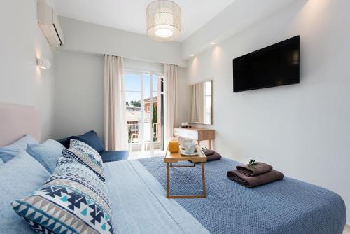 古维亚Marietta's Resort by Konnect, Gouvia Corfu的一间卧室配有蓝色的床和电视