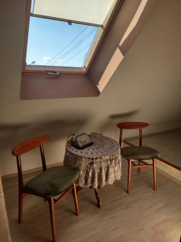 蒂科钦Loft 'PRL'的客房设有桌子、两把椅子和窗户。