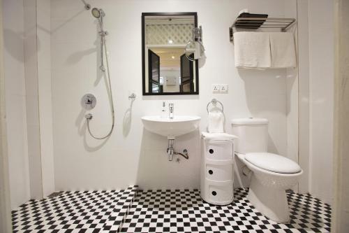 乔治市马车房酒店的白色的浴室设有水槽和卫生间。