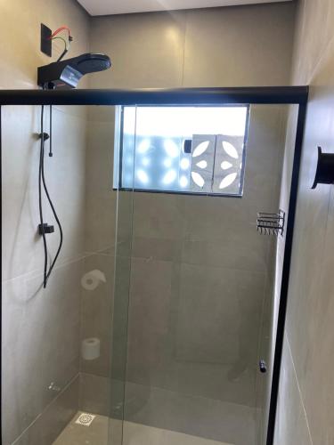 阿拉沙Loft de luxo的浴室里设有玻璃门淋浴